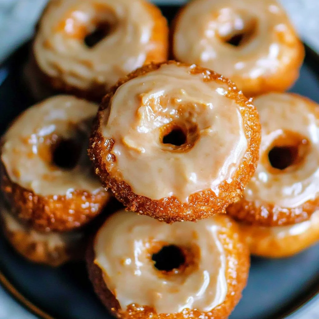 Baked pumpkin donuts drizzled with maple glaze on a plate