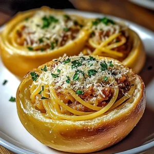 Spaghetti garlic bread bowls filled with pasta and topped with herbs