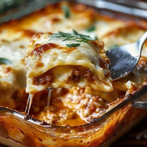 Baked Ravioli Casserole topped with cheese and herbs in a baking dish.