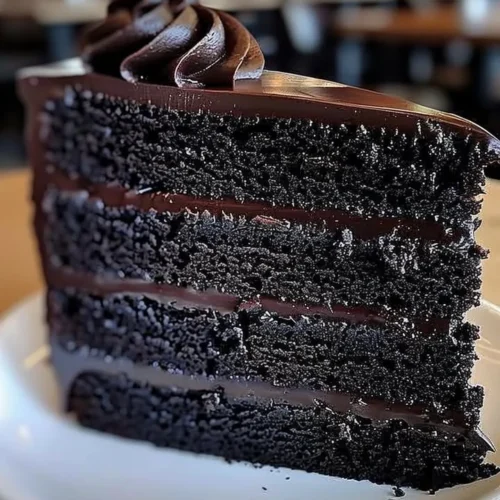 Delicious slice of Black Velvet Cake topped with creamy frosting.