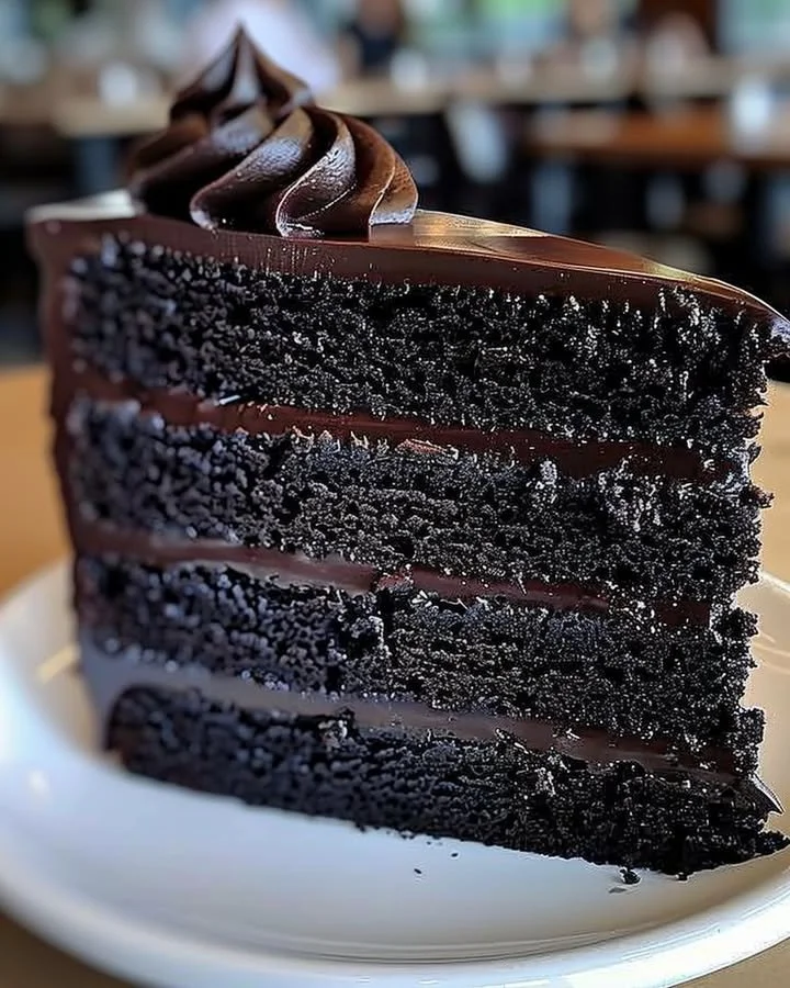 Delicious slice of Black Velvet Cake topped with creamy frosting.