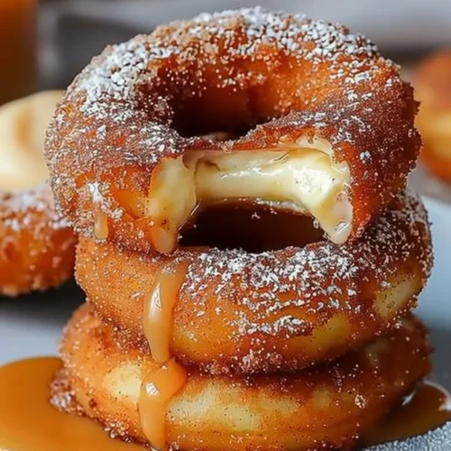 Delicious caramel cheesecake-stuffed churro rings on a plate