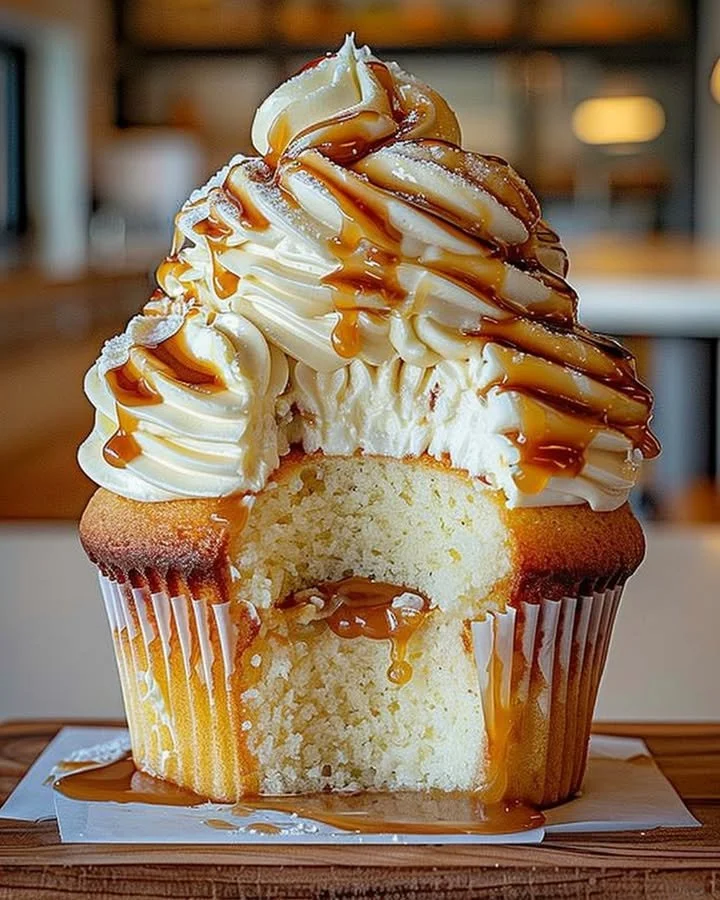 Caramel cupcake topped with cream cheese frosting on a decorative plate