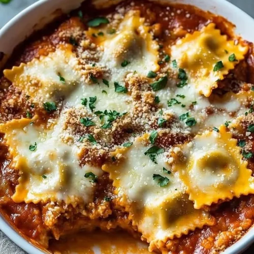 Cheesy baked ravioli casserole fresh out of the oven, garnished with parsley.