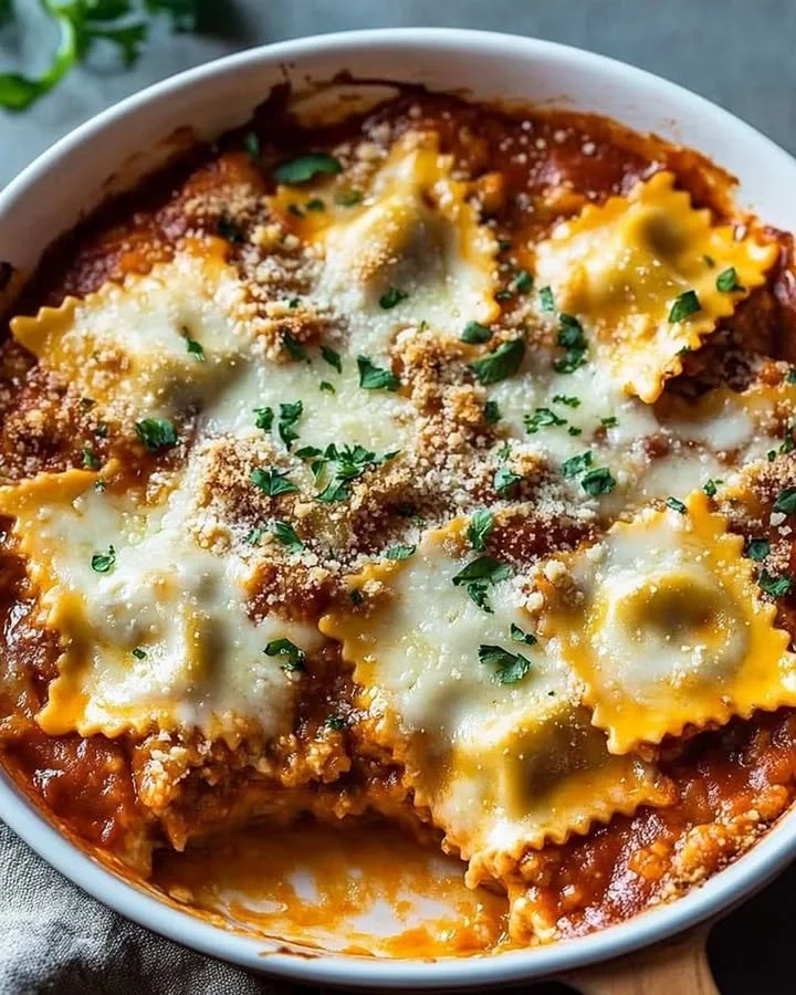 Cheesy baked ravioli casserole fresh out of the oven, garnished with parsley.