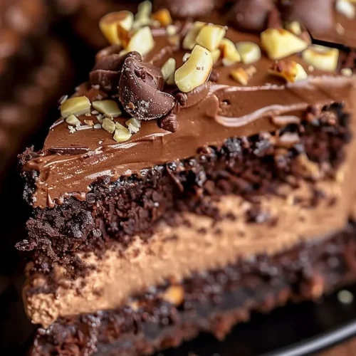 Slice of Chocolate Hazelnut Cheesecake Cake topped with chocolate ganache and hazelnuts