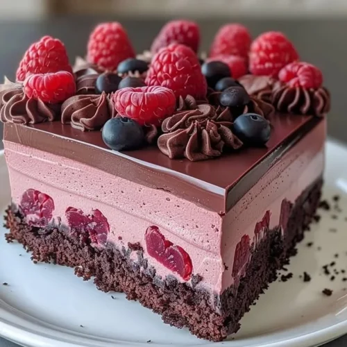 Decadent Chocolate Raspberry Mousse Cake topped with fresh raspberries and chocolate shavings