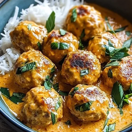 Plate of Coconut Chicken Meatballs garnished with herbs and served with sauce