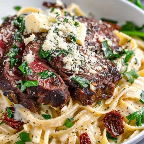 Delicious plate of Copycat Steak Gorgonzola Alfredo with creamy sauce and steak.