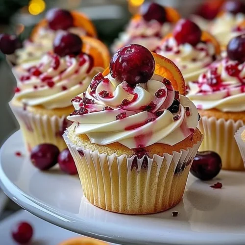 Cranberry Orange White Chocolate Cupcakes with vibrant frosting on a plate