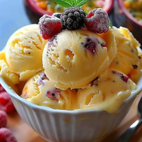 Creamy passion fruit ice cream served with tropical fruits and a mint garnish.