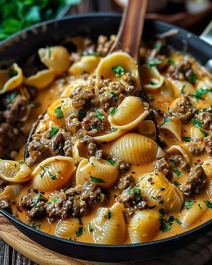 Creamy beef shells casserole dish topped with melted cheese and herbs