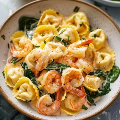 Creamy lemon shrimp tortellini served in a bowl garnished with herbs