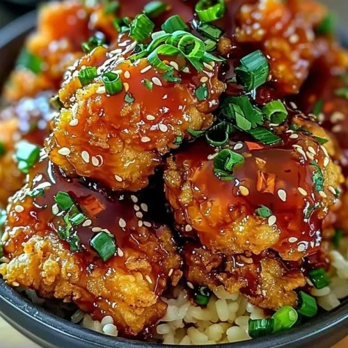 Crispy Bang Bang Chicken served with spicy dipping sauce and garnished
