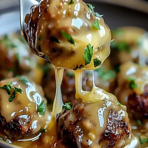 Delicious French Onion Meatballs cooked in a crock pot, topped with melted cheese