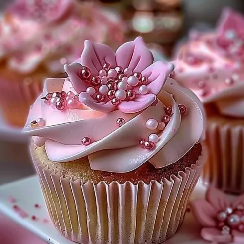 Elegant pink buttercream cupcakes topped with delicate decorations