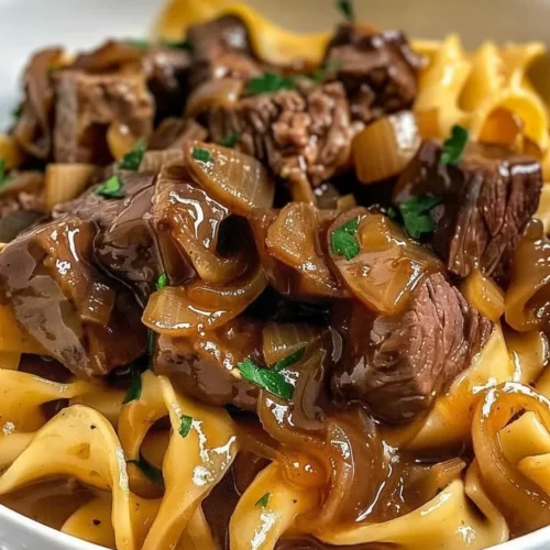 Delicious French onion beef and noodles served in a bowl with melted cheese