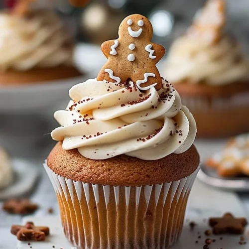 Delicious gingerbread cupcakes decorated with frosting and holiday sprinkles.