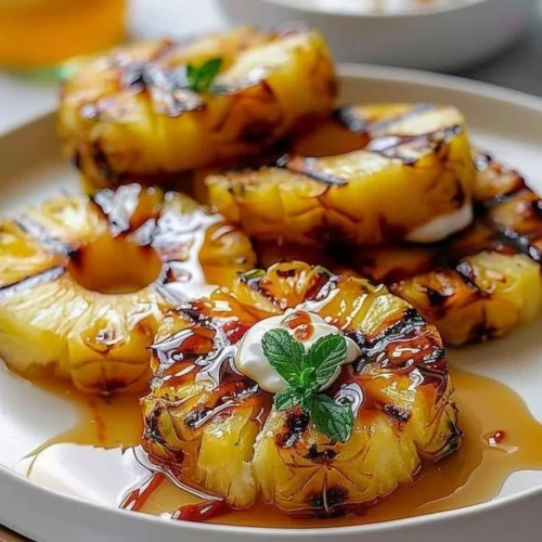 Sweet and caramelized grilled pineapple slices on a BBQ grill.