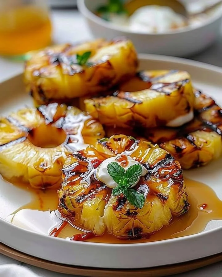 Sweet and caramelized grilled pineapple slices on a BBQ grill.