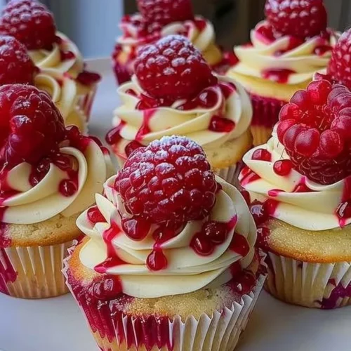 Heavenly raspberry cheesecake cupcakes topped with fresh raspberries.