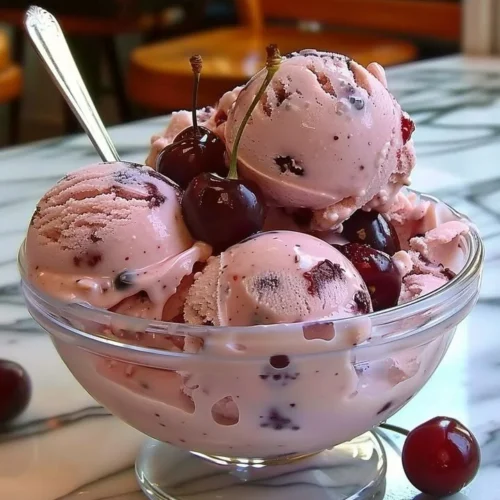 Bowl of homemade cherry ice cream topped with fresh cherries
