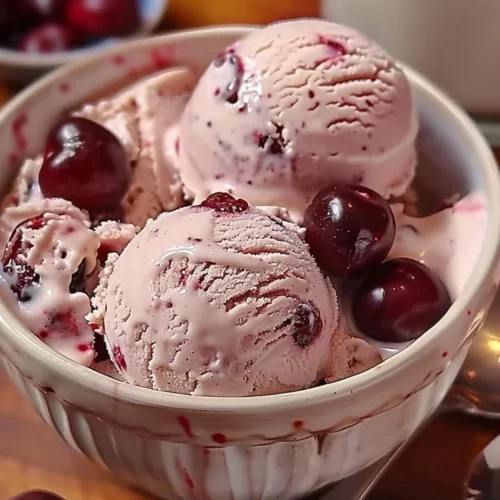 Bowl of homemade cherry vanilla ice cream with fresh cherries and vanilla beans