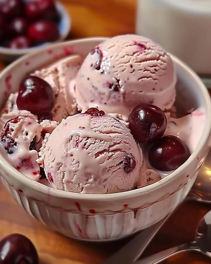 Bowl of homemade cherry vanilla ice cream with fresh cherries and vanilla beans