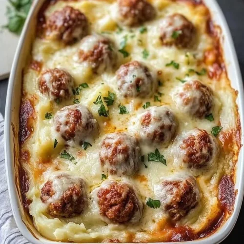 Loaded mashed potatoes casserole with meatballs served in a baking dish