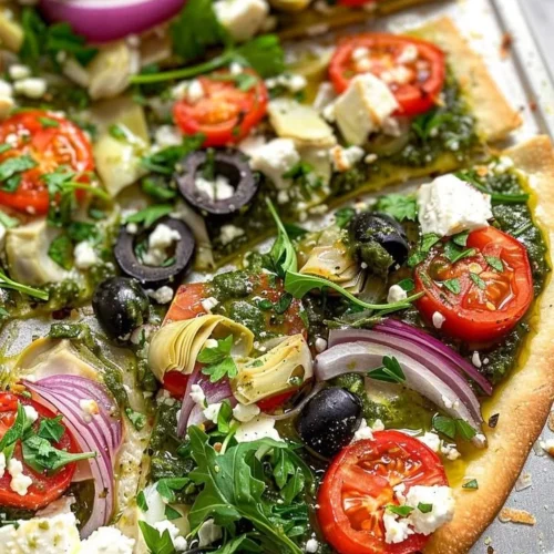 Delicious Mediterranean Veggie Flatbread topped with fresh vegetables and herbs.