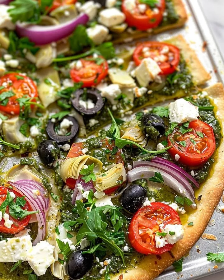Delicious Mediterranean Veggie Flatbread topped with fresh vegetables and herbs.