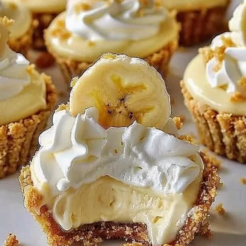 No-bake mini banana cream pies topped with whipped cream and banana slices.