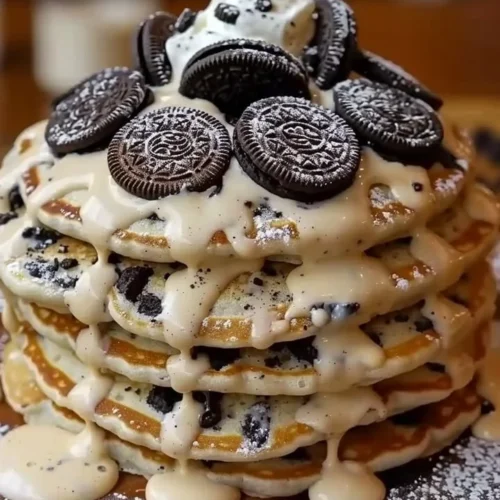 Oreo Pancakes drizzled with cream cheese for a sweet breakfast treat.