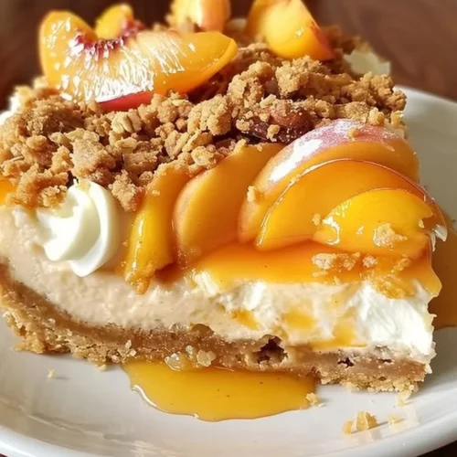 Delicious Peach Cobbler Cheesecake topped with fresh peaches