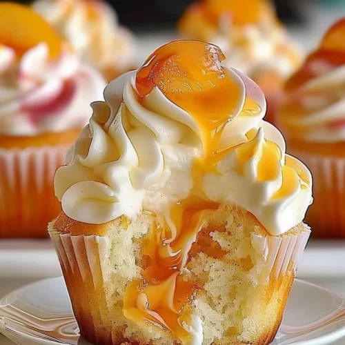 Delicious homemade peach cupcakes topped with creamy frosting and fresh peach slices.