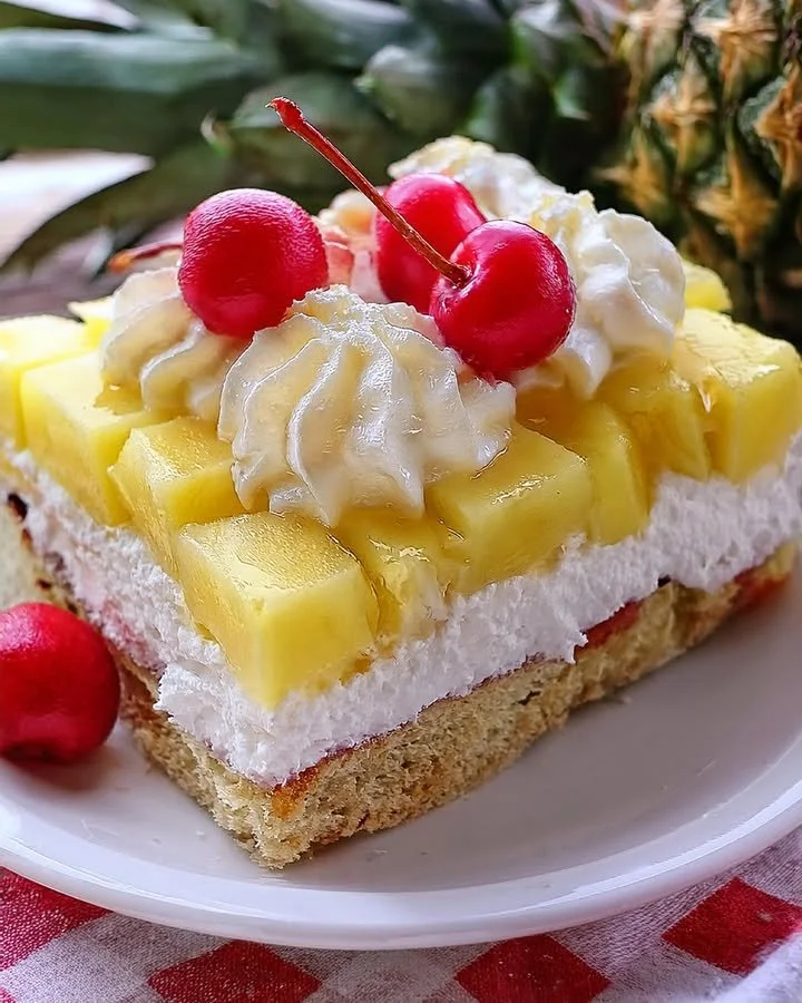 Delicious Pineapple Heaven Cake topped with fresh pineapple slices and whipped cream