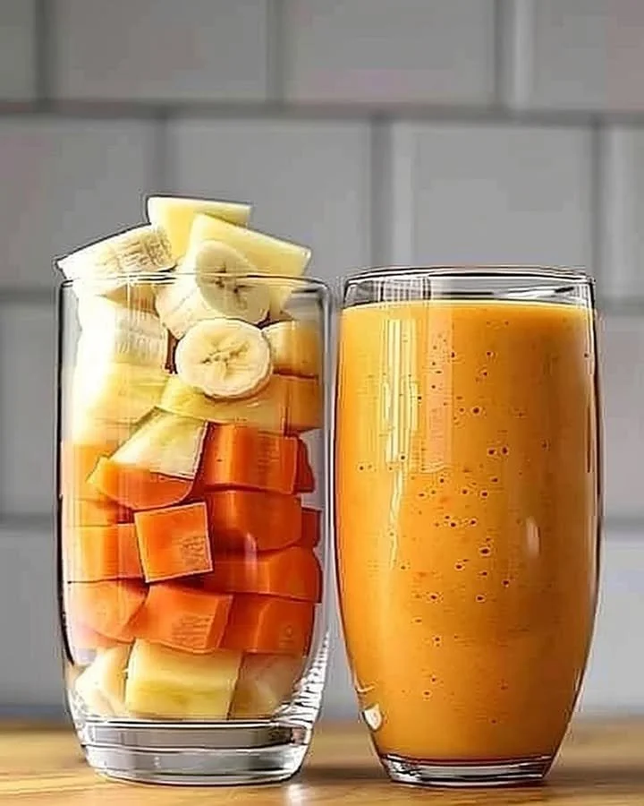 A vibrant Pineapple Orange Carrot Smoothie in a glass with fresh ingredients.