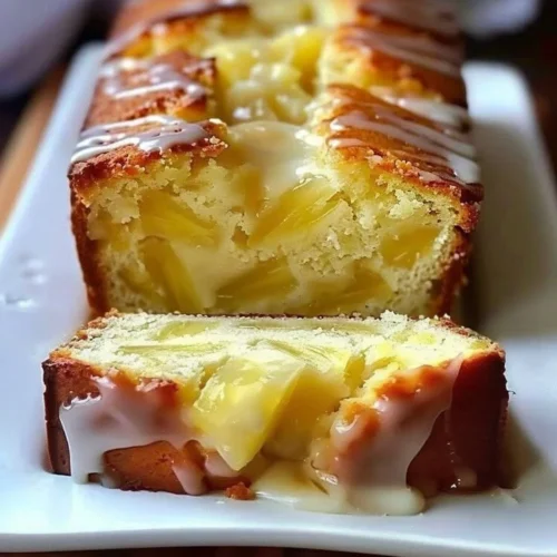 Delicious slice of homemade pineapple quick bread on a wooden table