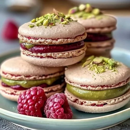 Delicious homemade Raspberry Pistachio Macarons arranged on a decorative plate.
