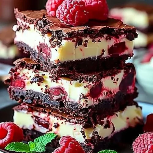 Delicious Red Velvet Brownies stacked on a plate with cream cheese frosting