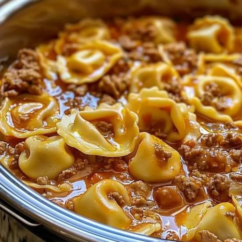 Delicious slow cooker cheesy tortellini served in a bowl with garnish.