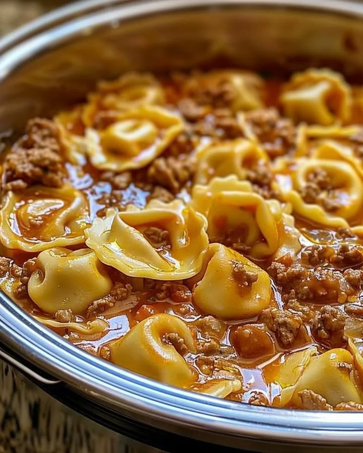 Delicious slow cooker cheesy tortellini served in a bowl with garnish.