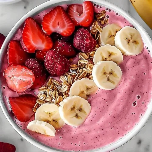 Delicious Strawberry Banana Smoothie in a glass topped with fresh fruit