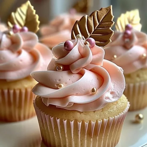 Vanilla cupcakes decorated with blush pink buttercream frosting on a decorative plate